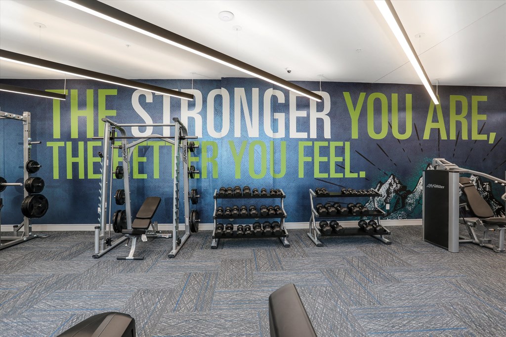 a fitness room with a wall mural that says the stronger you are the fit you a fitness room with a wall mural that says the stronger you are the fit you at Beekman on Broadway, Ann Arbor, MI